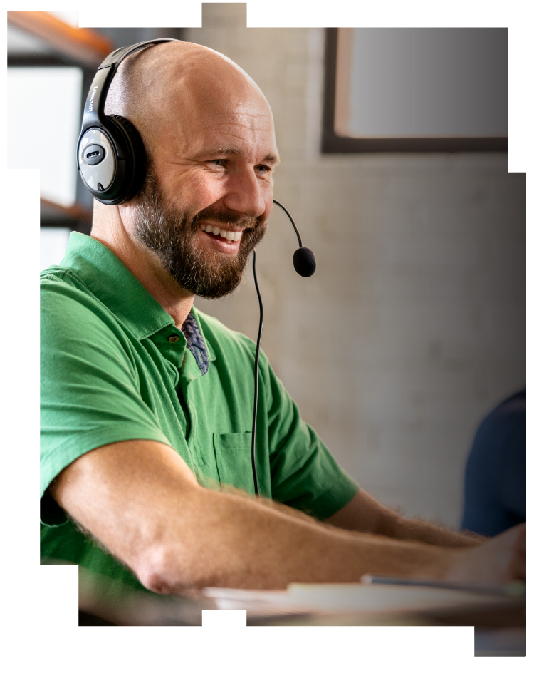 A smiling man wearing a headset and a green shirt